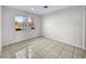 Cozy bedroom with neutral walls, tile flooring, base molding, and sun-filled windows at 9609 Rolling Thunder Ave, Las Vegas, NV 89148