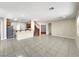 Open-concept living room with tile flooring, adjoining kitchen and stairway to the second floor at 9609 Rolling Thunder Ave, Las Vegas, NV 89148