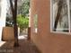 View of side yard with textured stucco, gate to shared space and mature tree at 9937 La Paca Ave, Las Vegas, NV 89117