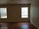 Bright bedroom featuring wood floors and two sunny windows with blinds at 9937 La Paca Ave, Las Vegas, NV 89117