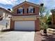 Two-story home featuring an attached garage, standard driveway, and desert-style xeriscape at 9937 La Paca Ave, Las Vegas, NV 89117