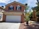 Two-story home featuring an attached garage, standard driveway, and desert-style xeriscape at 9937 La Paca Ave, Las Vegas, NV 89117