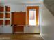 Living room featuring custom built-ins, warm orange accent wall, and natural lighting at 9937 La Paca Ave, Las Vegas, NV 89117