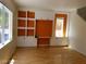 A living room with natural light, wooden floor, and white shelves over orange accent wall at 9937 La Paca Ave, Las Vegas, NV 89117