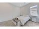 Neutral bedroom features a twin bed with a window and a bench-style drawer cabinet at , Henderson, NV 89011
