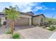 Desert home exterior features a brick driveway, a two-car garage, and desert landscaping at , Henderson, NV 89011