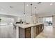Open-concept kitchen with island, white countertops, dark cabinets, stainless steel appliances, and adjacent dining and living areas at , Henderson, NV 89011