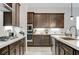 A modern kitchen featuring dark wood cabinetry, white countertops, and stainless steel appliances at , Henderson, NV 89011