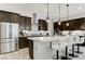 Contemporary kitchen with stainless steel appliances, island with seating, and dark cabinets at , Henderson, NV 89011