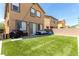Inviting backyard features artificial turf, patio, bbq, seating, and string lights for entertaining at 10086 Adina Ct, Las Vegas, NV 89141