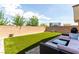 Wide backyard with green lawn, patio furniture, and privacy wall at 10086 Adina Ct, Las Vegas, NV 89141