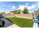 Manicured backyard with synthetic grass, patio with seating and privacy wall at 10086 Adina Ct, Las Vegas, NV 89141