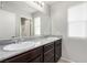 Modern bathroom featuring double sinks, granite counters, and a large mirror at 10086 Adina Ct, Las Vegas, NV 89141
