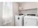 Well-lit laundry room with a washer, dryer, storage basket and window at 10086 Adina Ct, Las Vegas, NV 89141
