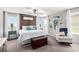 Bright main bedroom featuring a decorative wooden headboard, ample natural light, and a cozy seating area at 10086 Adina Ct, Las Vegas, NV 89141