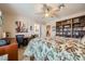 Bedroom features neutral carpet, ceiling fan, large bed, built-in bookcase and home office space at 10456 Prairie Schooner Ave, Las Vegas, NV 89129