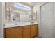 Bright bathroom with a large mirror, white countertops, and light wood cabinetry offers a fresh, clean design at 10468 Concetta Ave, Las Vegas, NV 89129