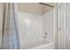 Clean, white tiled bathtub and shower combination with a blue striped shower curtain for a simple and functional design at 10468 Concetta Ave, Las Vegas, NV 89129