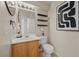 Updated half bathroom with modern fixtures, shelving, and an art piece at 10468 Concetta Ave, Las Vegas, NV 89129