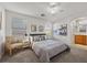 Bright bedroom featuring a ceiling fan, windows, and ensuite bathroom at 10468 Concetta Ave, Las Vegas, NV 89129