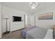 Bright bedroom featuring a ceiling fan and dresser with a television at 10468 Concetta Ave, Las Vegas, NV 89129
