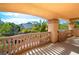 Balcony with stone railing and pillars offers views of the neighborhood and mature trees at 10798 Tapestry Winds St, Las Vegas, NV 89141