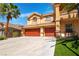 Beautifully landscaped two-story home with a three-car garage and well-maintained lawn at 10798 Tapestry Winds St, Las Vegas, NV 89141