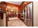 Open kitchen with dark wood cabinets, stainless appliances and adjacent dining room at 10798 Tapestry Winds St, Las Vegas, NV 89141