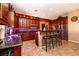Modern kitchen features dark wood cabinets, stainless steel appliances and tiled floor at 10798 Tapestry Winds St, Las Vegas, NV 89141