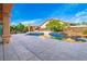 Inviting backyard pool with rock waterfall feature, spacious patio, and covered lounge area at 10798 Tapestry Winds St, Las Vegas, NV 89141