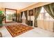 Bright sitting room with elegant curtains, a large mirror, and a decorative rug at 10798 Tapestry Winds St, Las Vegas, NV 89141
