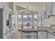 The modern kitchen features granite countertops, stainless steel appliances, and a breakfast nook with bright windows at 11076 Zampino St, Las Vegas, NV 89141