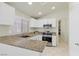The kitchen has white cabinets, granite counters, stainless steel appliances, and tile flooring at 11076 Zampino St, Las Vegas, NV 89141