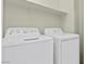 Practical laundry room with a side-by-side washer and dryer and a shelf for storage at 11076 Zampino St, Las Vegas, NV 89141