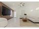 Spacious living room with neutral decor, tile floors, and modern ceiling fan at 11076 Zampino St, Las Vegas, NV 89141