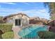An inviting in-ground pool surrounded by lush landscaping and a private backyard at 11076 Zampino St, Las Vegas, NV 89141