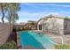 Backyard view of in-ground pool with lush landscaping and a patio area at 11076 Zampino St, Las Vegas, NV 89141