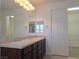 Bathroom features double sinks with dark wood cabinetry and large mirror at 11298 Corsica Mist Ave, Las Vegas, NV 89135