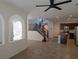Open living room featuring arched doorways, staircase, kitchen, tile floors, and natural light at 11298 Corsica Mist Ave, Las Vegas, NV 89135