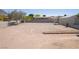 Spacious, vacant backyard with dirt ground cover surrounded by block wall and fences at 1227 San Gabriel Ave, Henderson, NV 89002