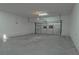 Empty garage with a standard roll up door, cement floor, and overhead lighting at 1227 San Gabriel Ave, Henderson, NV 89002
