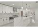 Open white kitchen featuring stainless appliances, marble counters and backsplash, and a stylish island at 1227 San Gabriel Ave, Henderson, NV 89002