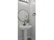 Bathroom with modern pedestal sink and round mirror at 12525 Lylan Ridge St, Las Vegas, NV 89138