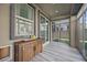 Enclosed sunroom with grey-toned floors, a wood credenza, and natural light from the sliding glass doors at 12525 Lylan Ridge St, Las Vegas, NV 89138