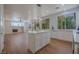Bright kitchen features an island, white cabinets, wood floors, and large windows with natural light at 1371 Cumulus Ct, Henderson, NV 89014