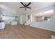 Open-concept living room featuring wood floors, a ceiling fan, and connections to the kitchen and entry at 1371 Cumulus Ct, Henderson, NV 89014