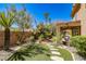 Backyard featuring artificial grass, stepping stones, rock landscaping, and tropical trees and plants at 1737 Cypress Manor Dr, Henderson, NV 89012