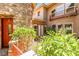 Inviting stone facade entrance with a red door and lush landscaping adds curb appeal to the property at 1737 Cypress Manor Dr, Henderson, NV 89012