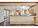 Open-concept kitchen featuring modern lighting fixtures, granite countertops, and stainless steel appliances at 1737 Cypress Manor Dr, Henderson, NV 89012