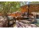 Tropical pool area featuring a built-in BBQ, stone waterfall, Tiki umbrella, and lush landscaping at 1737 Cypress Manor Dr, Henderson, NV 89012